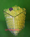 A flower vase of glass filled with yellow hydroponic jelly beads can be used with plants soil.