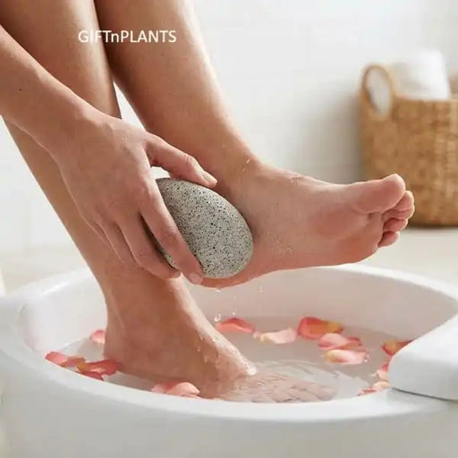 A person washing his feet with warm water, holding a natural pumice stone scrubber during his pedicure. 
